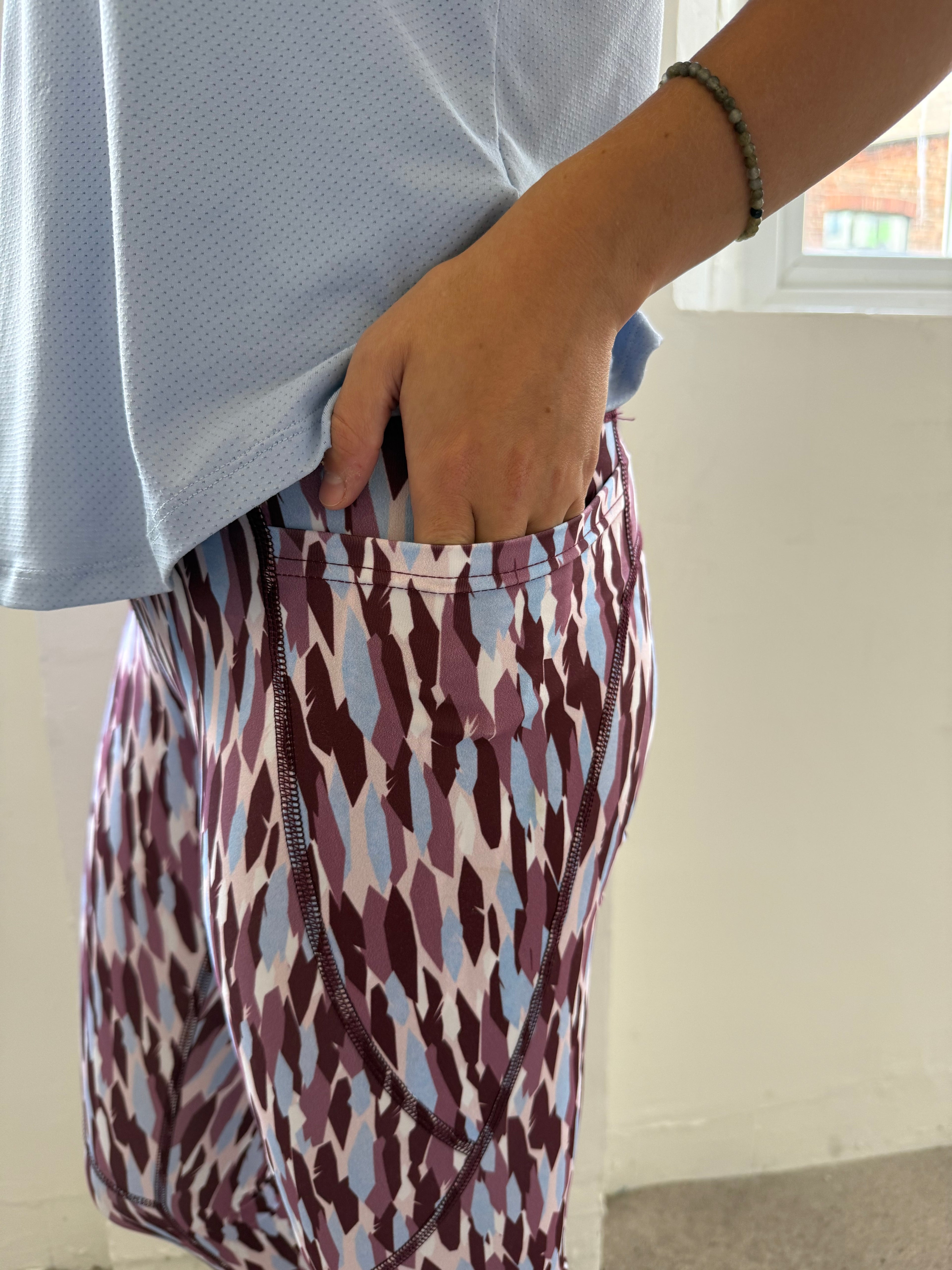 Person folding a patterned fabric item on a flat surface.