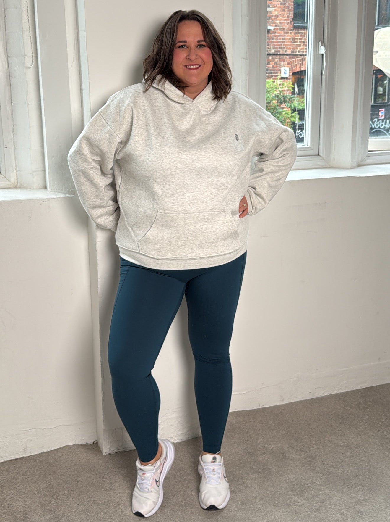 Woman wearing show up club hoodie and soul soft leggings
