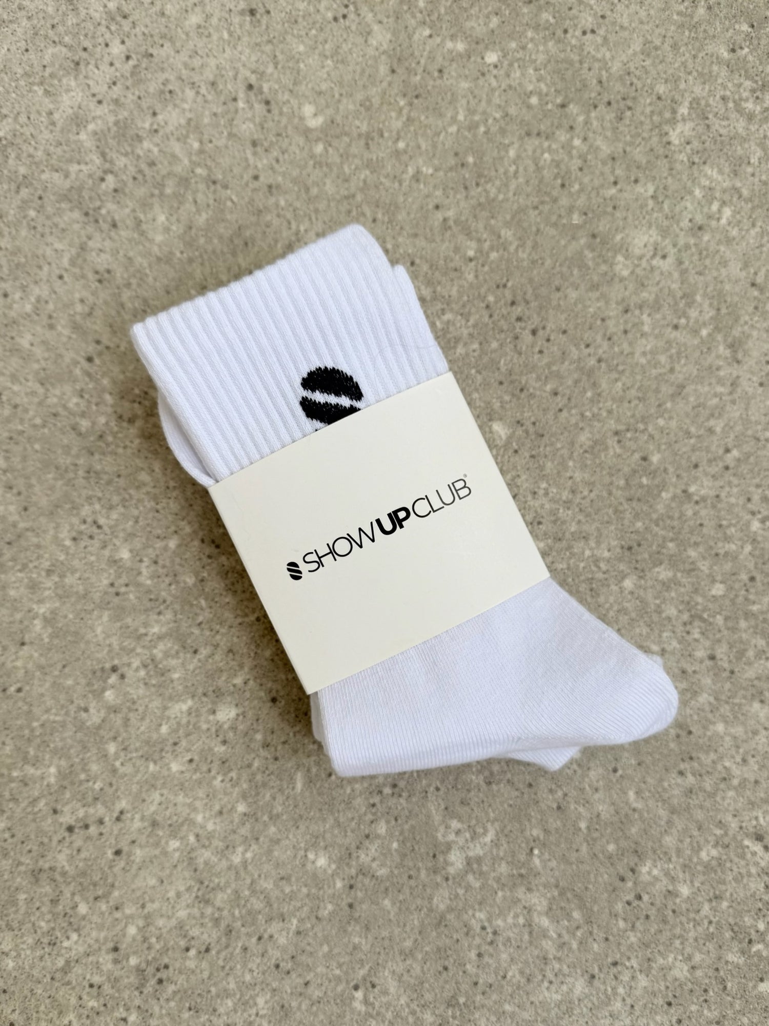 White sock with a visible brand label on a beige surface.