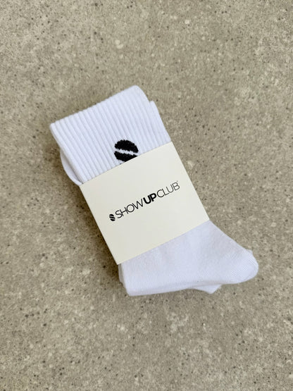 White sock with a visible brand label on a beige surface.