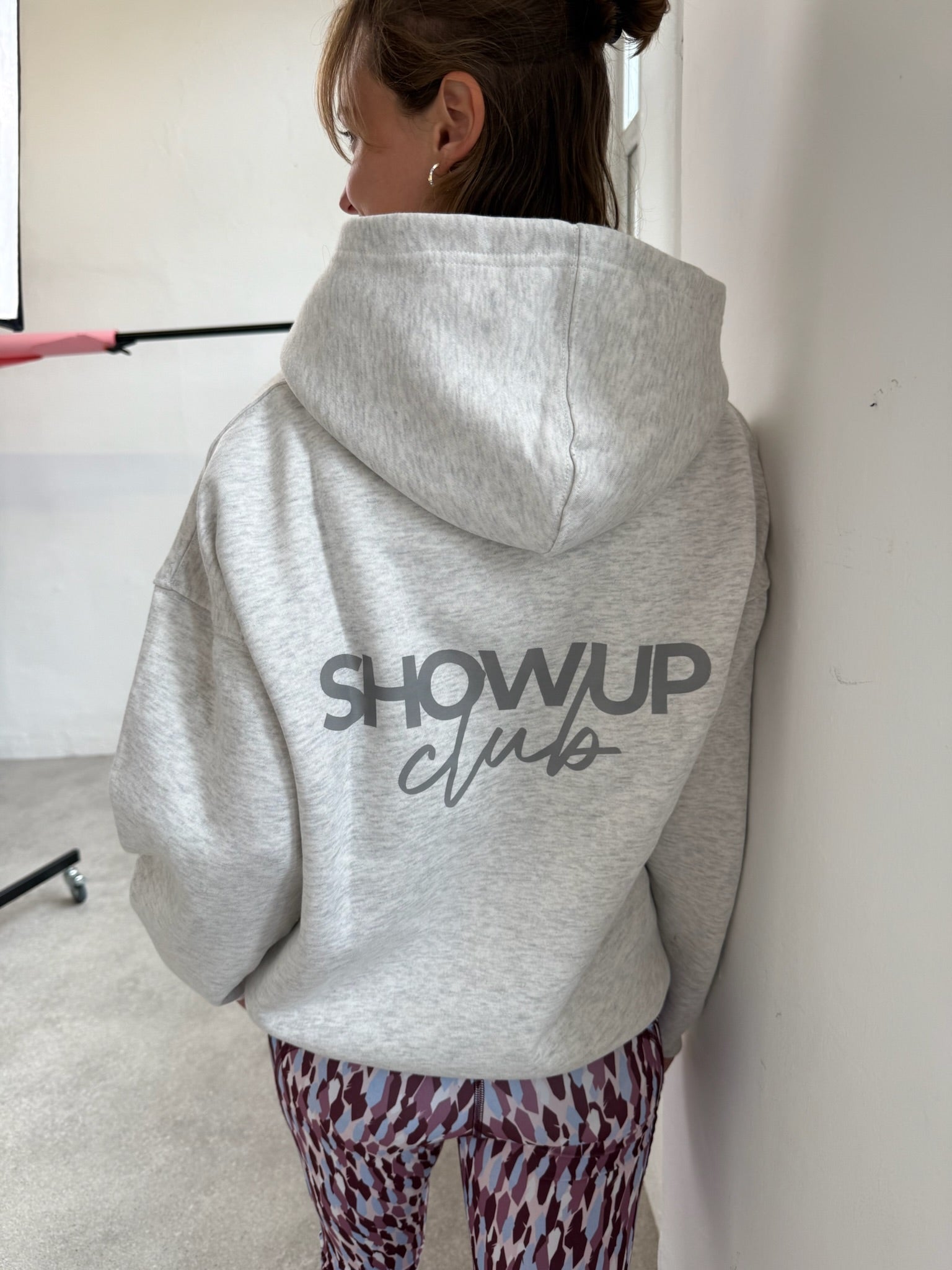 Person wearing a gray hoodie with &
