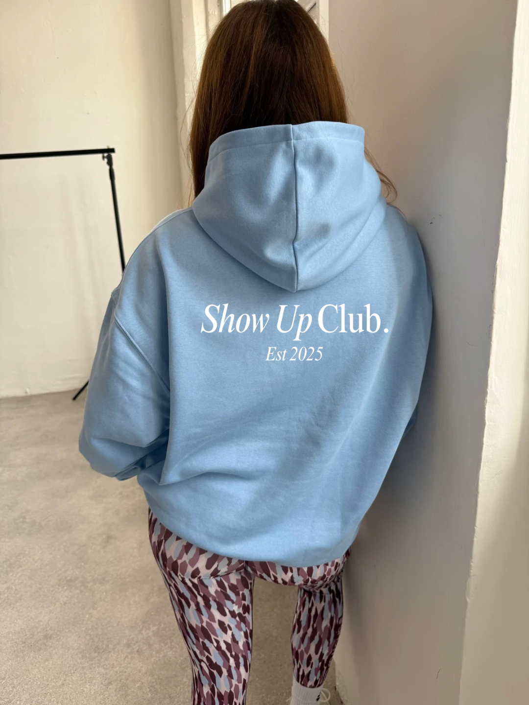 Person wearing a light blue hoodie with &