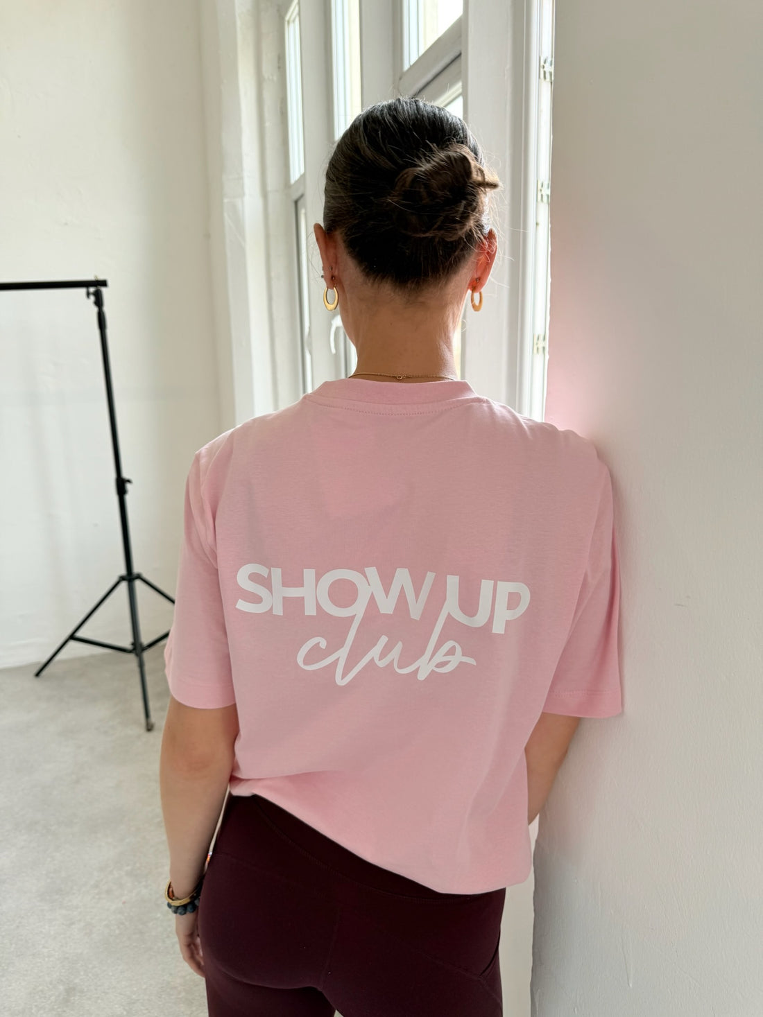 Person wearing a pink t-shirt with &